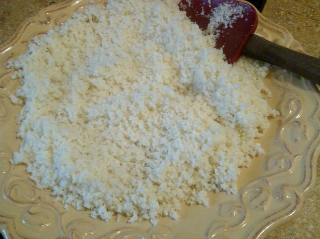 Cooling cauliflower "rice" on a plate after gently sauteing for a few minutes in coconut oil and adding rice vinegar
